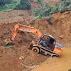Các phương tiện máy móc tập trung xử lý hàng ngàn mét khối bùn đất trong vụ sạt lở. (Ảnh Đức Thọ/TTXVN)