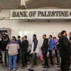 Người dân Palestine xếp hàng tại một máy ATM bên ngoài chi nhánh Ngân hàng Palestine ở Rafah, phía Nam Dải Gaza. (Nguồn: Flash90)