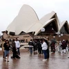 Khách du lịch tham quan khu vực Nhà hát Opera ở Sydney, Australia. (Ảnh: Getty Images/TTXVN)