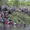 Người di cư vượt sông từ Mexico vào Mỹ ngày 11/5/2023. (Ảnh: Getty Images/TTXVN)