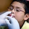 Xịt vắcxin phòng cúm H1N1 cho học sinh tiểu học. (Ảnh: AFP/TTXVN)