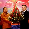Thứ trưởng Bộ An Ninh Kào Somkeo Silavong (bên trái) tặng hoa chúc mừng Xuân Giáp Ngọ 2014. (Ảnh: Hoàng Chương/Vietnam+)