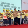 Thủ tướng Nguyễn Tấn Dũng tặng quà cho người khuyết tật. (Ảnh: Đức Tám/TTXVN)