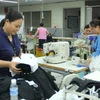 Công nhân Công ty Esquel Garment Manuflecturing tại Khu công nghiệp Việt Nam-Singapore, tỉnh Bình Dương, đã trở lại làm việc. (Ảnh: Thanh Vũ/TTXVN)