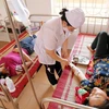 Bác sỹ Trung tâm Y tế huyện Yên Bình chăm sóc cho nạn nhân bị ngộ độc thực phẩm. (Ảnh: Trung Kiên/TTXVN)