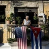 Một người dân treo cờ Mỹ và Cuba ở ban công của một ngôi nhà tại La Habana của Cuba. (Nguồn: AP)