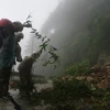 Công nhân Hạt Giao thông 4 thu dọn đất đá ở những điểm sạt lở trên tuyến đường lên Khu du lịch Mẫu Sơn, Lạng Sơn. (Ảnh: Doãn Hoàng Nam/TTXVN) 