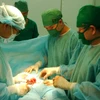 Các bác sỹ Bệnh viện Bình Dân An Giang và Bệnh viên Bình Dân TP.HCM thực hiện phẫu thuật bóc tách khối u cho bệnh nhân. (Ảnh: Công Mạo/TTXVN)