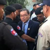 Cảnh sát Campuchia áp giải Thượng nghị sỹ Hong Sok Hour (giữa) tại Phnom Penh. (Ảnh: AFP/TTXVN)