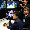 Tổng thống Hàn Quốc Park Geun-hye (giữa) điều khiển một cánh tay robot trong chuyến thăm Trung tâm Goddard. (Ảnh: Yonhap/TTXVN)