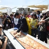 Nhân viên của Sách kỷ lục Guinness đo chiều dài chiếc bánh pizza tại Hội chợ triển lãm EXPO ở Milan. (Ảnh: AFP/TTXVN)