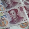 Đồng tiền giấy mệnh giá 100 NDT (15.5 USD) tại Bắc Kinh ngày 25/8 vừa qua. (Ảnh: AFP/TTXVN)