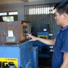 Công nhân khởi động máy phát điện chạy dầu diesel trên đảo Cù Lao Chàm. (Ảnh: Đỗ Trưởng/TTXVN)