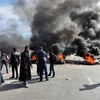 Người biểu tình đốt lốp xe phong tỏa một tuyến đường ở Medenine, unisia ngày 21/1 vừa qua. (Ảnh: AFP/TTXVN)