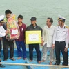 Cán bộ Vùng 3 Hải quân Đà Nẵng trao quà cho các thuyền viên vào bờ an toàn. (Ảnh Viết Ý/TTXVN)