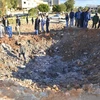 Người dân Libya vây quanh một hố bom sau cuộc không kích các mục tiêu IS tại Derna, cách thủ đô Tripoli, Libya khoảng 100km ngày 7/2 vừa qua. (Ảnh: AFP/TTXVN)
