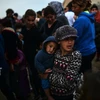 Người tị nạn và di cư xếp hàng đợi nhận khẩu phần ăn tại trại tị nạn ở Idomeni, biên giới Hy Lạp và Macedonia ngày 5/4. (Ảnh: AFP/TTXVN)