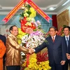 Ông Tất Thành Cang chúc mừng Tổng lãnh sự Lào Somxay Sanam-oune. (Ảnh: Phương Vy/TTXVN)