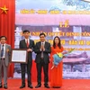Cục phó cục Di sản trao quyết định công nhận pho tượng Trấn Vũ - Bảo vật quốc gia cho lãnh đạo phường Thạch Bàn - quận Long Biên. (Ảnh: Minh Đức/TTXVN)