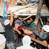 Lực lượng cứu hộ giải cứu người còn sống bị mắc kẹt trong một căn nhà đổ nát sau trận động đất ở Manta. (Ảnh: AFP/TTXVN)