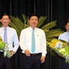 Bí thư Thành ủy Thành phố Hồ Chí Minh Đinh La Thăng chúc mừng 2 tân Phó Chủ tịch UBND Trần Vĩnh Tuyến và Huỳnh Cách Mạng. (Ảnh: Thanh Vũ/TTXVN)
