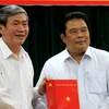 Thường trực Ban Bí thư Đinh Thế Huynh (trái) trao quyết định của Bộ Chính trị cho ông Sơn Minh Thắng. (Ảnh: Ngọc Thiện/TTXVN)