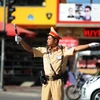Lực lượng cảnh sát giao thông vẫn phải duy trì công việc tại những nút giao thông trọng yếu. (Ảnh: Quang Quyết/TTXVN)