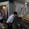Nhân viên Thú y kiểm tra xuất xứ sản phẩm thịt đông lạnh tại Công ty TNHH thương mại dịch vụ thực phẩm An Hà xã Vân Nội, huyện Đông Anh, thành phố Hà Nội. (Ảnh: Vũ Sinh/TTXVN)