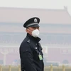 Cảnh sát Trung Quốc đeo khẩu trang tránh khói mù ô nhiễm tại thủ đô Bắc Kinh. (Ảnh: Reuters/TTXVN)
