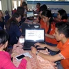 Nhân viên Công ty FPT hỗ trợ người dân truy cập Internet đặt mua vé tàu Tết Đinh Dậu 2017 tại ga Sài Gòn. )Ảnh: Hoàng Hải/TTXVN)