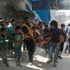 Chuyển thi thể một nạn nhân sau một vụ không kích tại Fardous, khu vực lân cận thành phố Aleppo ngày 12/10 vừa qua. (Ảnh: AFP/TTXVN)