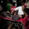 Các nhân viên cứu hộ Pakistan và tình nguyện viên đưa nạn nhân bị thương của một vụ nổ bom tại một ngôi đền Sufi đến bệnh viện. (Nguồn: AP)