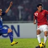 Tiền đạo Irfan Bachdim (phải), đội Indonesia trong pha tranh bóng với cầu thủ Kovanh Namthavixay, đội Lào. (Ảnh: AFP/TTXVN)