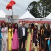 Đại sứ Việt Nam tại Argentina Nguyễn Đình Thao chụp ảnh ảnh các bạn biểu diễn áo dài tại sự kiện. (Ảnh: Phương Lan/Vietnam+)