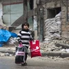 Người dân Syria sơ tán khỏi các khu vực do quân nổi dậy kiểm soát để đến các khu vực đã được quân Chính phủ giải phóng ở Aleppo ngày 13/12. (Ảnh: AFP/TTXVN)