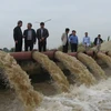 Lãnh đạo Sở Nông nghiệp và Phát triển Nông thôn Hà Nội kiểm tra lấy nước ở trạm bơm Ấp Bắc. (Ảnh: Đỗ Phương Anh/TTXVN)