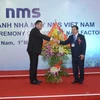 Chủ tịch UBND tỉnh Hà Nam Nguyễn Xuân Đông tặng hoa chúc mừng lãnh đạo Nhà máy NMS Việt Nam. (Ảnh: Nguyễn Chinh/TTXVN)