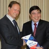 Đại sứ Bruno Angelet tặng sách trắng cho Chủ tịch UBND TP Hồ Chí Minh Nguyễn Thành Phong. (Ảnh: Thanh Vũ/TTXVN)
