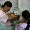 Nhân viên y tế hướng dẫn các bà mẹ đến hiến tặng sữa cách sử dụng máy hút sữa. (Ảnh: Trần Lê Lâm/TTXVN)