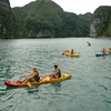 Du khách bơi thuyền Kayak trên Vịnh Hạ Long. (Ảnh: Tiến Dũng/TTXVN) 
