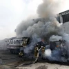 Nhân viên cứu hỏa dập lửa sau khi xe buýt bị đốt phá tại Rio de Janeiro, ngày 2/5. (Ảnh: EPA/TTXVN)