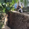 Đất bị sụt lún sâu sau nhà một hộ gia đình. (Ảnh minh họa: Huyền Trang/TTXVN)