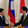 Thủ tướng Nhật Bản Shinzo Abe - bên phải và Thủ tướng Lào Thongloun Sisolith. (Ảnh: AFP/TTXVN)