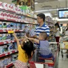 Người tiêu dùng chọn mua sản phẩm sữa tại siêu thị. (Ảnh: Thanh Vũ/TTXVN)