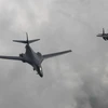 Máy bay ném bom B1-B của Mỹ (trái) thực hiện hành trình bay 10 giờ từ Căn cứ không quân Andersen, đảo Guam đến bán đảo Triều Tiên ngày 30/7 vừa qua. (Ảnh: EPA/TTXVN)