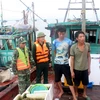 Lực lượng chức năng tiến hành kiểm tra tàu vi phạm khai thác thủy sản trái phép. (Ảnh: Nguyễn Hoàng/TTXVN)