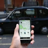 Một khách hàng dùng điện thoại di động để gọi dịch vụ xe của Uber tại London. (Ảnh: AFP/TTXVN )