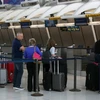Hành khách làm thủ tục tại quầy của hãng hàng không Air France ở sân bay quốc tế John F. Kennedy, New York, Mỹ. (Ảnh: AFP/TTXVN)