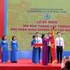 Chủ tịch Quốc Hội Nguyễn Thị Kim Ngân gắn Huân chương Độc lập hạng Nhất lên lá cờ truyền thống của Trường THCS Trưng Vương. (Ảnh: Quý Trung/TTXVN)