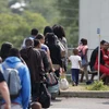Một nhóm người xin tị nạn chờ đợi để được giải quyết sau khi được hộ tống từ trại lều của họ đến Dịch vụ Biên giới Canada ở Lacolle, Quebec, Canada. (Nguồn: reuters)
